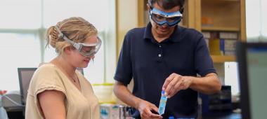 Image of Susquehanna professor and student in chemistry lab with beakers.